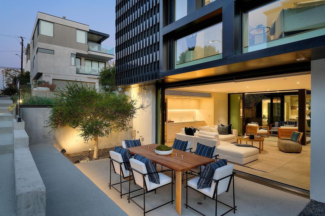 Alma Switch House lower terrace at dusk, living space open to the outdoor dining area