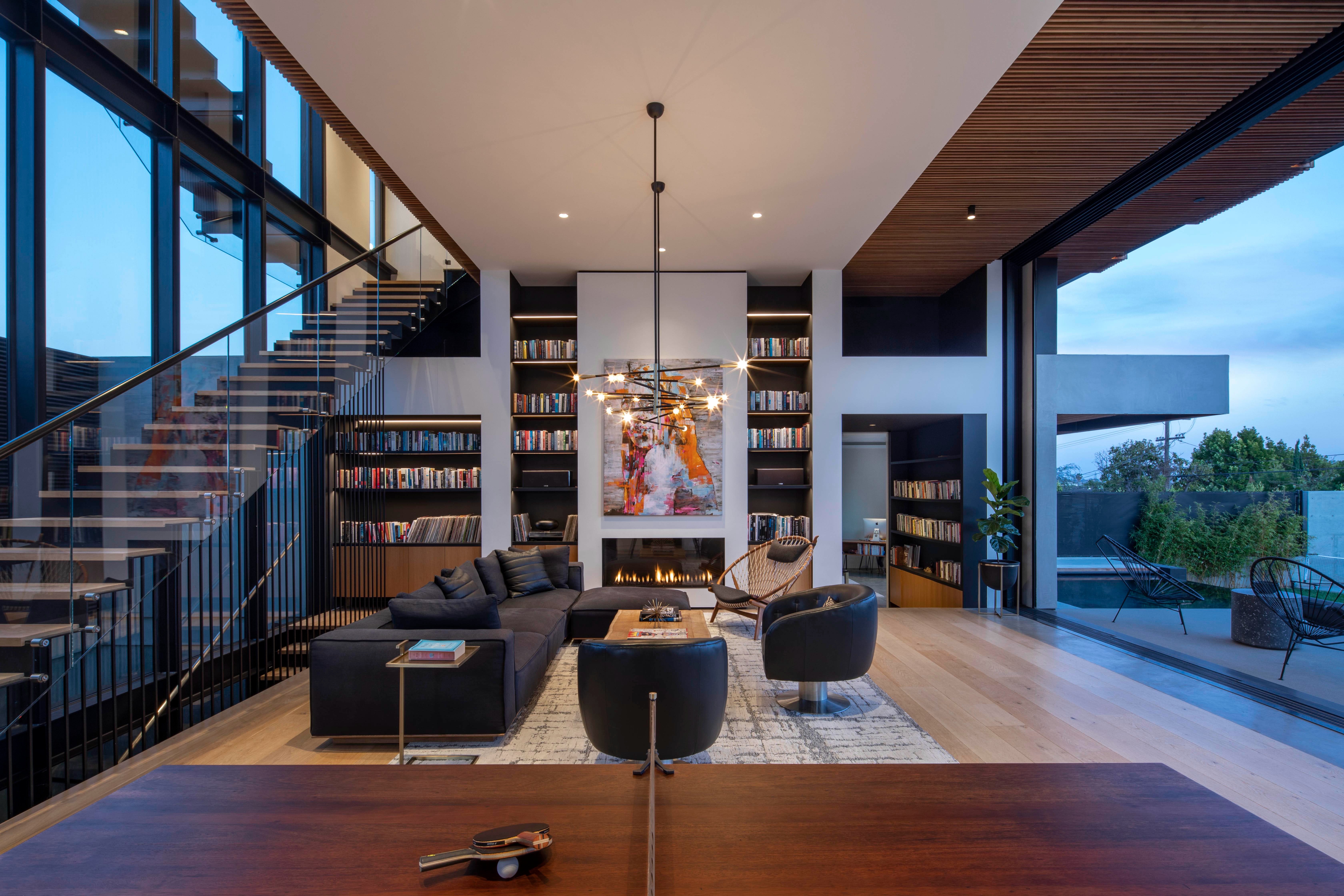 Wasatch Residence: double-height living room with a full-height library, linear fireplace and floating oak stair